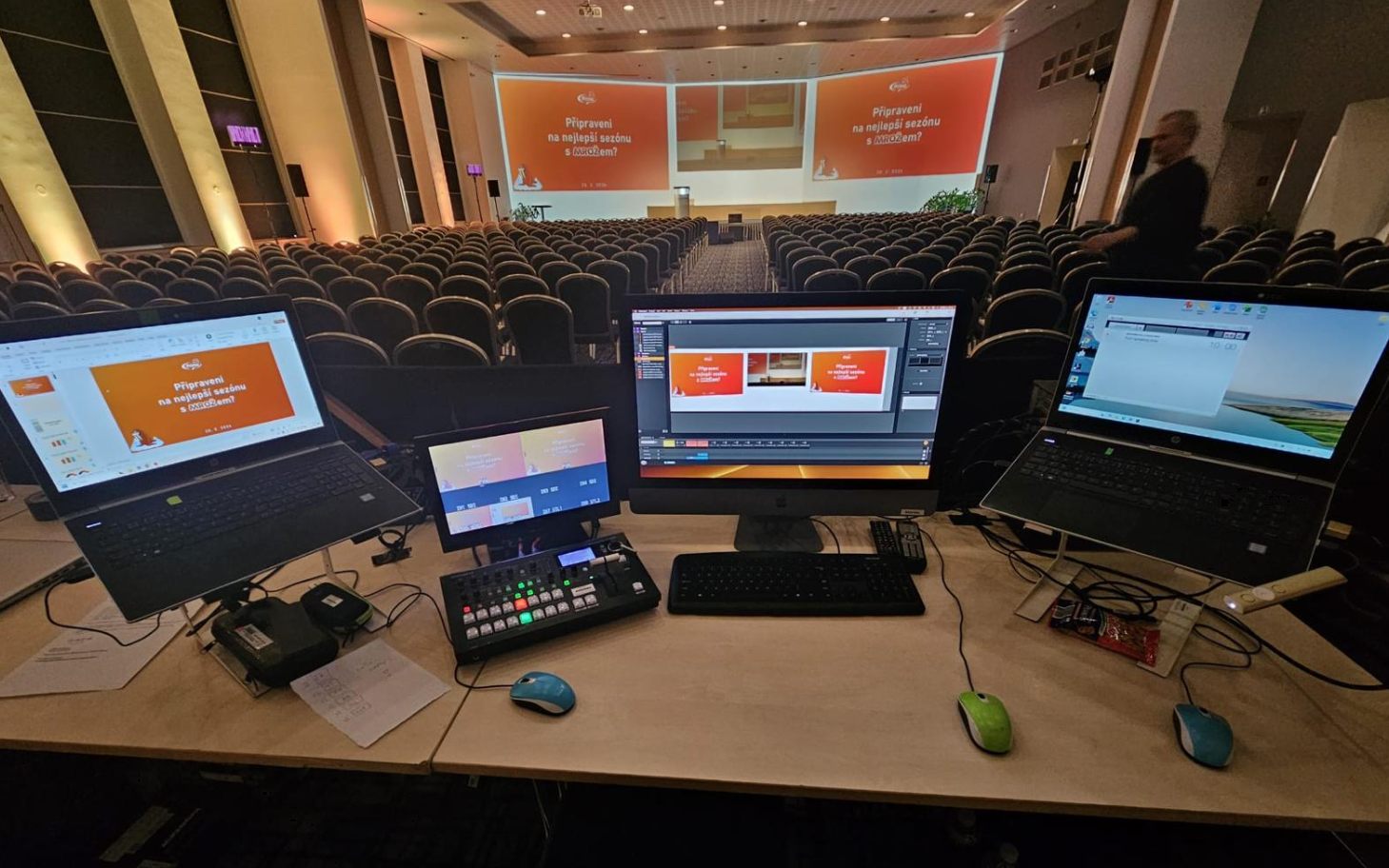 Režijní stanoviště s mixem, střihem a notebooky během konference